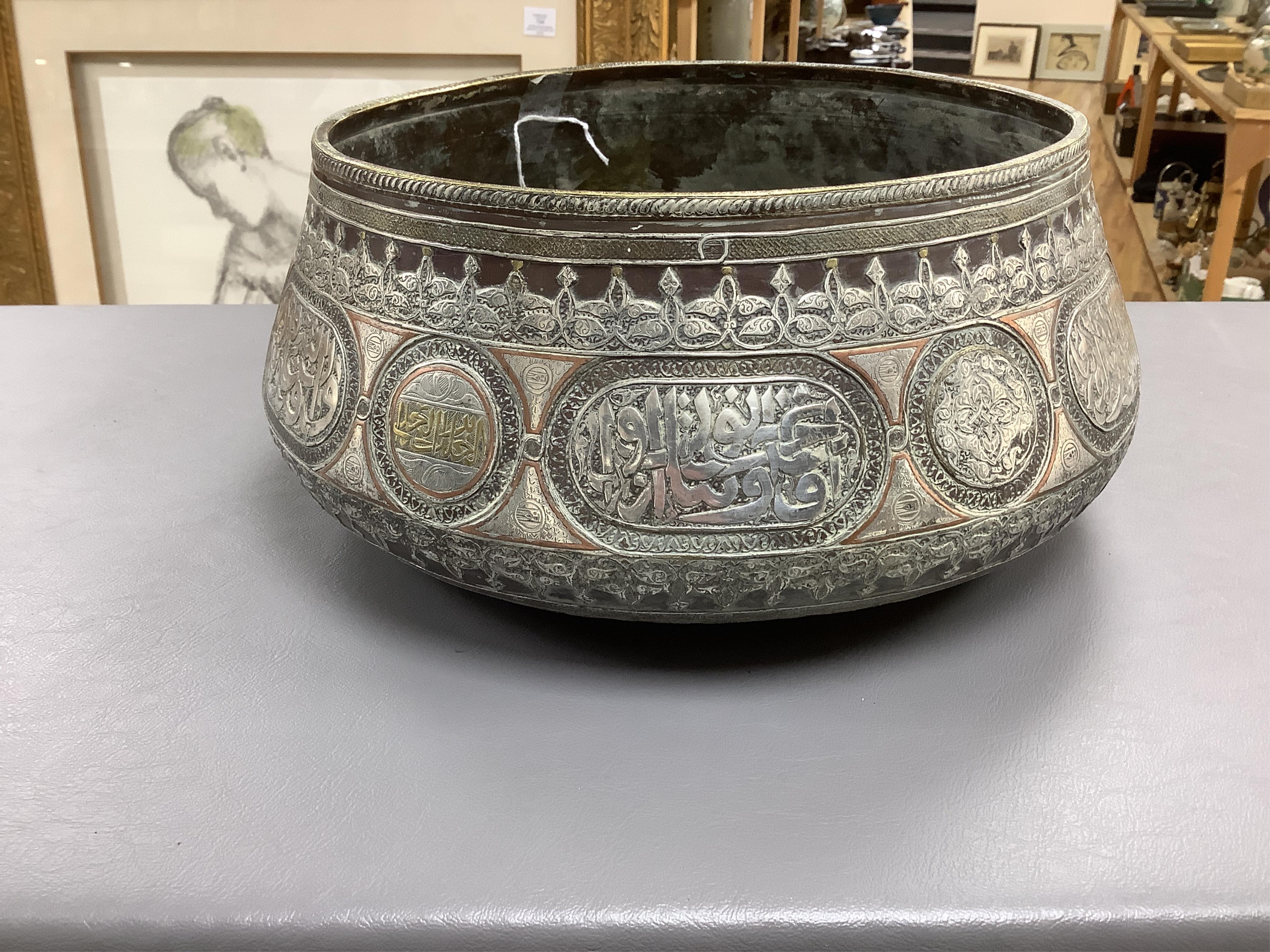 A late 19th century Mamluk style brass basin inlaid with silver and copper decoration, 29cm diameter
